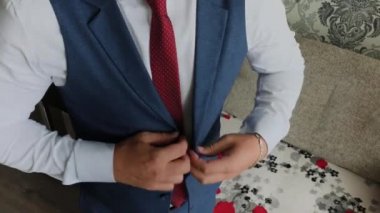 İşadamı parlak bir odada ceketini bağladı.