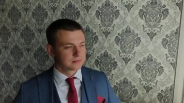 İşadamı parlak bir odada ceketini bağladı.