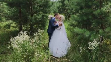 Çok güzel gelin ve damat ormanda el ele tutuşup kucaklaşın.