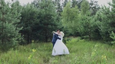 Çok güzel gelin ve damat ormanda el ele tutuşup kucaklaşın.