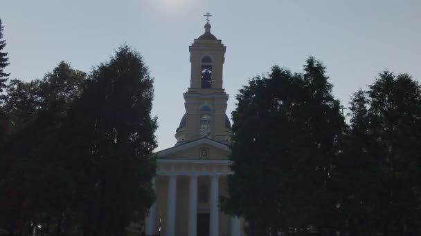 Hermosa iglesia grande entre los árboles en un día soleado . — Vídeo de stock