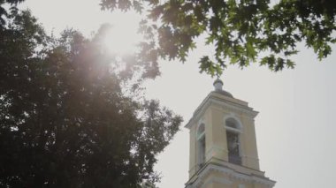 Güneşli bir günde ağaçların arasında güzel büyük kilise.