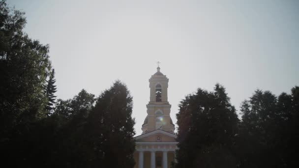 Hermosa iglesia grande entre los árboles en un día soleado . — Vídeo de stock