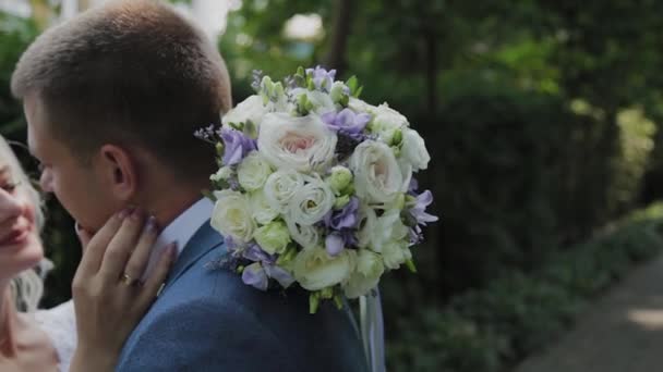 Happy jonggehuwden knuffel kus in Park. — Stockvideo