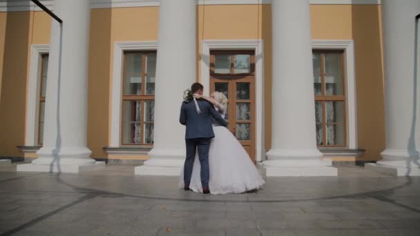 Mutlu yeni evliler parktaki sütunlarda dans ederler.. — Stok video
