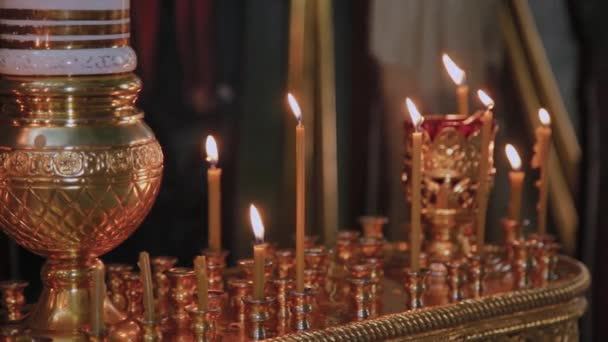 Kaarsen op een kandelaar in een kerk. Religieuze feestdag. — Stockvideo