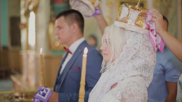 Jonggehuwden bij de huwelijksceremonie in de kerk. — Stockvideo