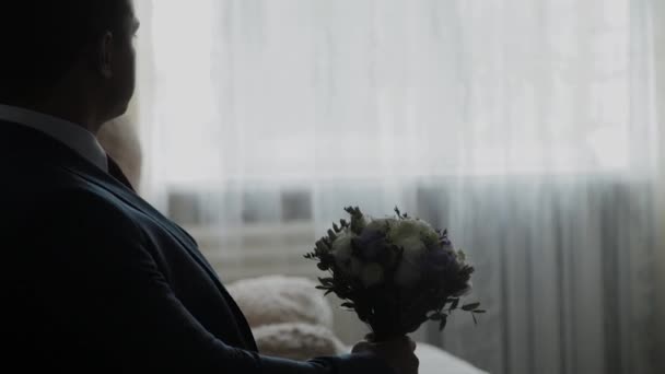 Giovane sposo con un bouquet sul divano . — Video Stock