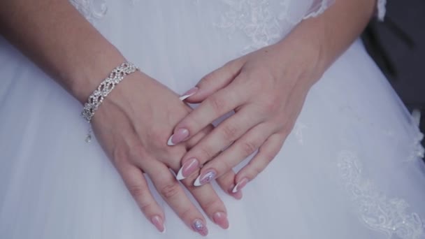 Manhã de noivas. As mãos de uma noiva close-up estão em um vestido de casamento branco. Bela noiva em um vestido de noiva branco . — Vídeo de Stock