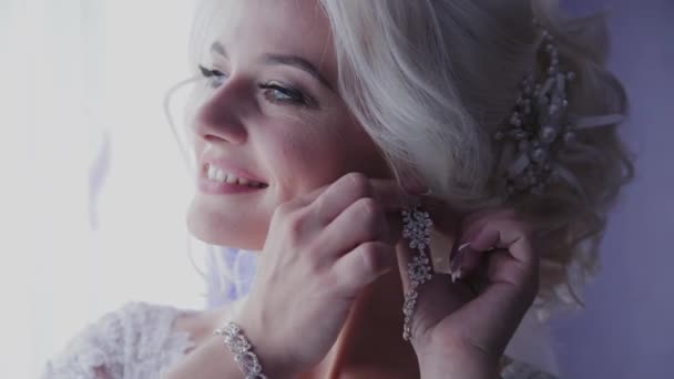 Gyönyörű menyasszony bezárja fülbevalót az ablakon. — Stock videók