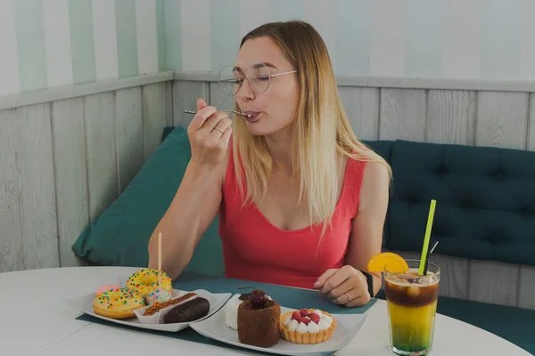 Meisje in een café eet zoete en verse desserts. — Stockfoto