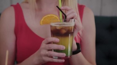 Güzel kız bir restoranda bir kokteyl içiyor.