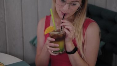 Güzel kız bir restoranda bir kokteyl içiyor.