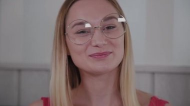 Güzel genç kız bir kafede bir masada oturur ve bir tabak tatlı taze tatlılar yiyor.