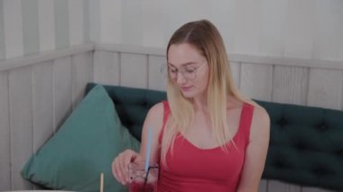 Güzel kız bir restoranda bir kokteyl içiyor.