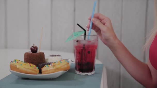 Schöne Mädchen trinkt einen Cocktail in einem Restaurant. — Stockvideo