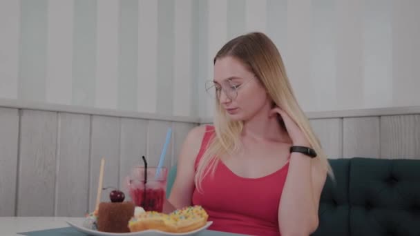 Красива дівчина п'є коктейль в ресторані . — стокове відео