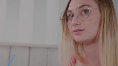 Güzel genç kız bir kafede bir masada oturur ve bir tabak tatlı taze tatlılar yiyor.