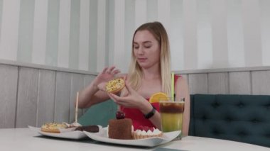 Güzel kız bir kafede bir masada elinde donut ile poz.
