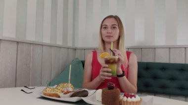 Güzel kız bir restoranda bir kokteyl içiyor.