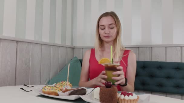 Красивая девушка пьет коктейль в ресторане . — стоковое видео