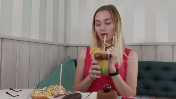 Hermosa chica bebe un cóctel en un restaurante . — Vídeo de stock