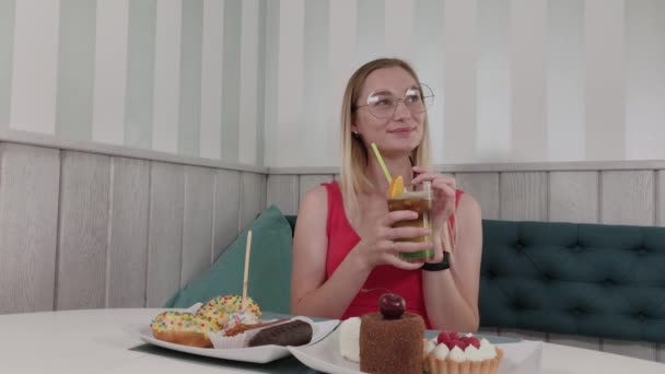 Hermosa chica bebe un cóctel en un restaurante . — Vídeo de stock