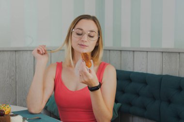 Bir kafede kız tatlı ve taze tatlılar yiyor.