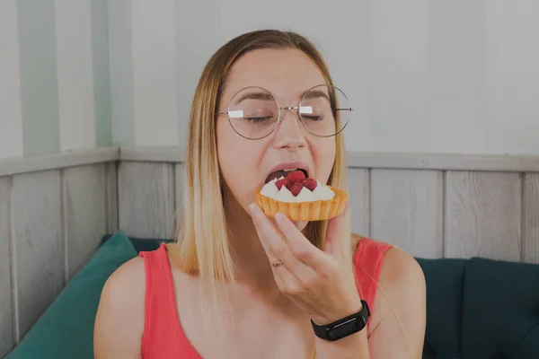 Menina em um café come sobremesas doces e frescas . — Fotografia de Stock