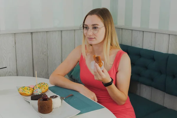 Chica en un café come postres dulces y frescos . — Foto de Stock