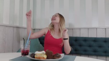 Güzel genç kız bir restoranda bir masada oturan dans.