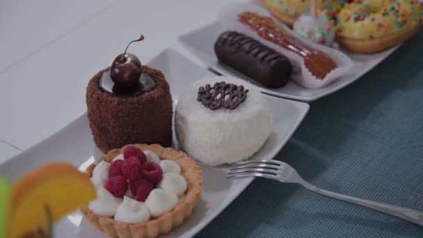 Teller mit schönen frischen Desserts auf einem Tisch in einem Café. — Stockvideo