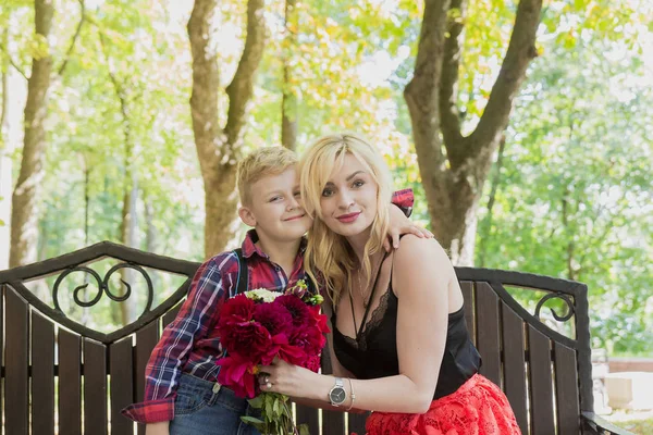 Pequeno menino bonito dá flores para a mãe . — Fotografia de Stock