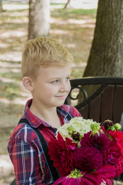 Kisfiú egy csokor virággal. — Stock Fotó