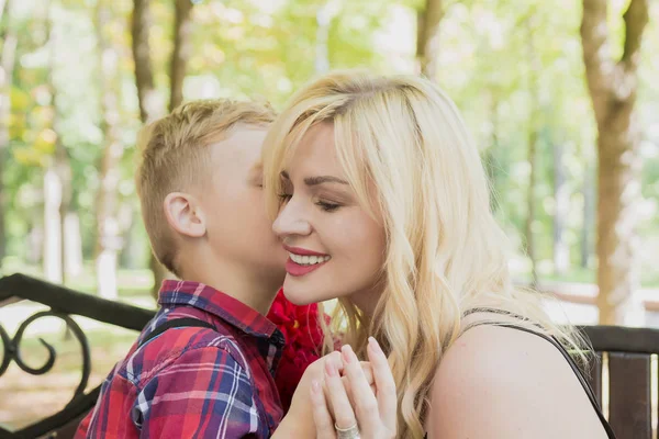 Pequeno menino bonito dá flores para a mãe . — Fotografia de Stock