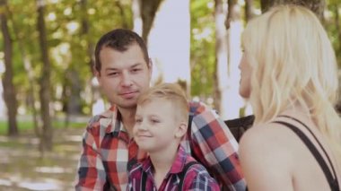 Güzel aile parkta bir bankta oturan ve konuşurken.