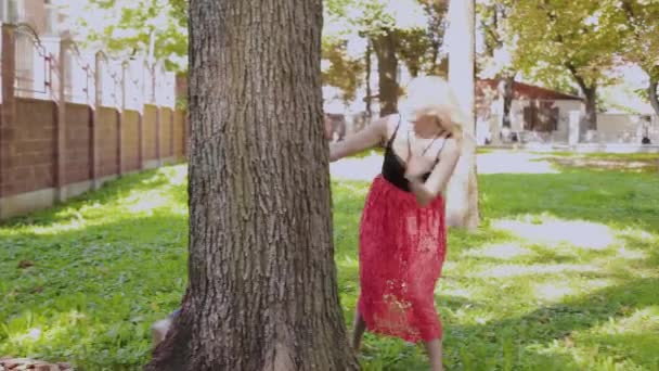 Feliz familia alegre abrazando y sonriendo por el árbol en el parque . — Vídeos de Stock