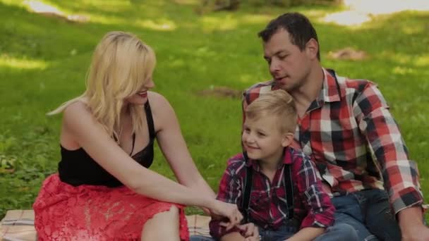 Hermosa familia feliz en un picnic en un día soleado . — Vídeo de stock