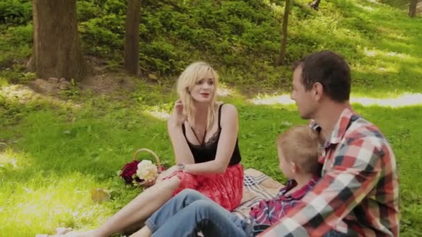 Hermosa familia feliz en un picnic en un día soleado . — Vídeos de Stock