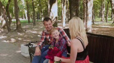 Güzel aile parkta bir bankta oturan ve konuşurken.