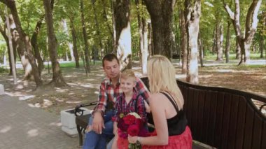 Güzel aile parkta bir bankta oturan ve konuşurken.