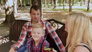 Güzel aile parkta bir bankta oturan ve konuşurken.