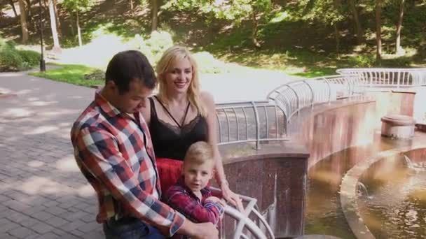 Η οικογένεια στέκεται δίπλα στη λίμνη στο πάρκο. — Αρχείο Βίντεο