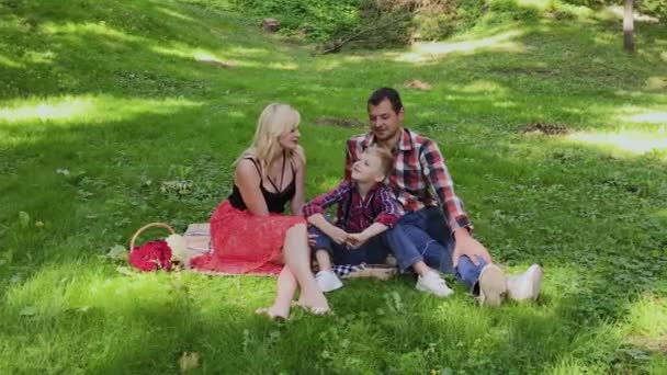 Hermosa familia feliz en un picnic en un día soleado . — Vídeo de stock