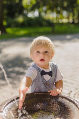 Güzel küçük çocuk parkta bir dere ile oynuyor..