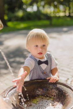 Güzel küçük çocuk parkta bir dere ile oynuyor..