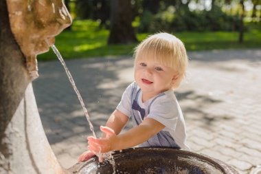 Güzel küçük çocuk parkta bir dere ile oynuyor..