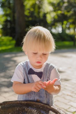 Güzel küçük çocuk parkta bir dere ile oynuyor..