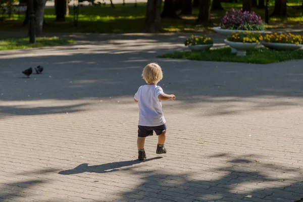 Kleiner Junge läuft im Park auf den Asphalt. — Stockfoto