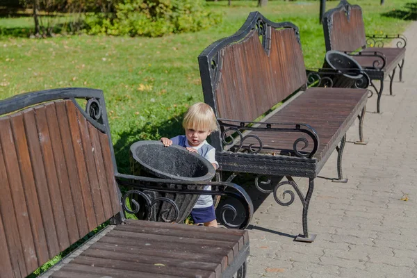 Little boy throws trash in the bin. — Stock Photo, Image